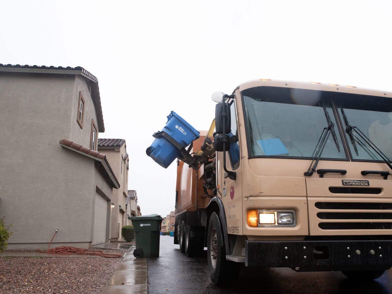 Collection truck picking up recycling container.
