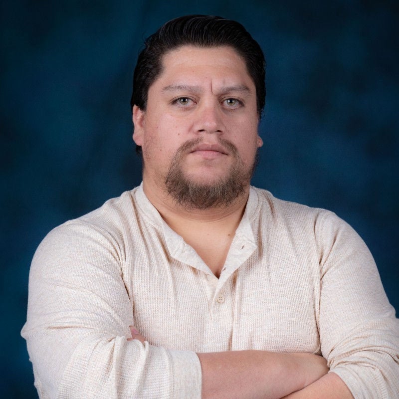 Man in white shirt standing in front of blue background