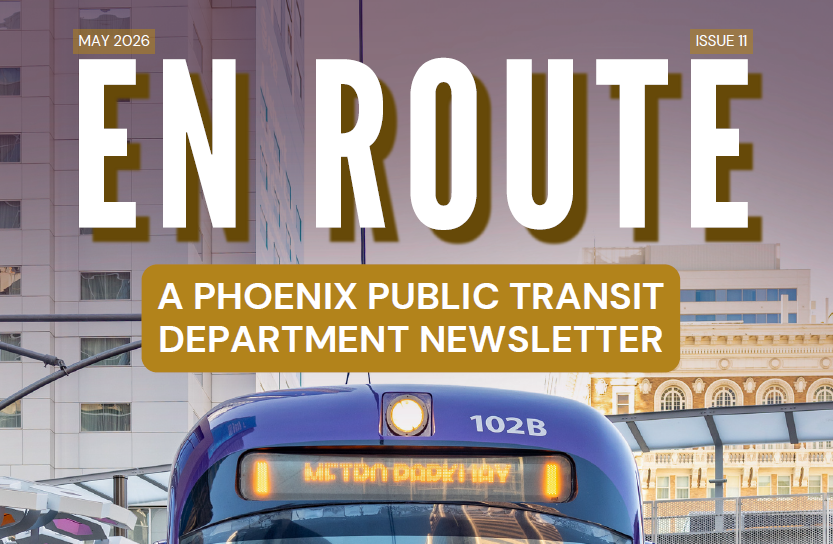 A picture of the top part of a purple light rail train with the title "En Route" and a sub-title "A Phoenix Public Transit Newsletter" in gold and white text. There is cityscape in the background of the image. 