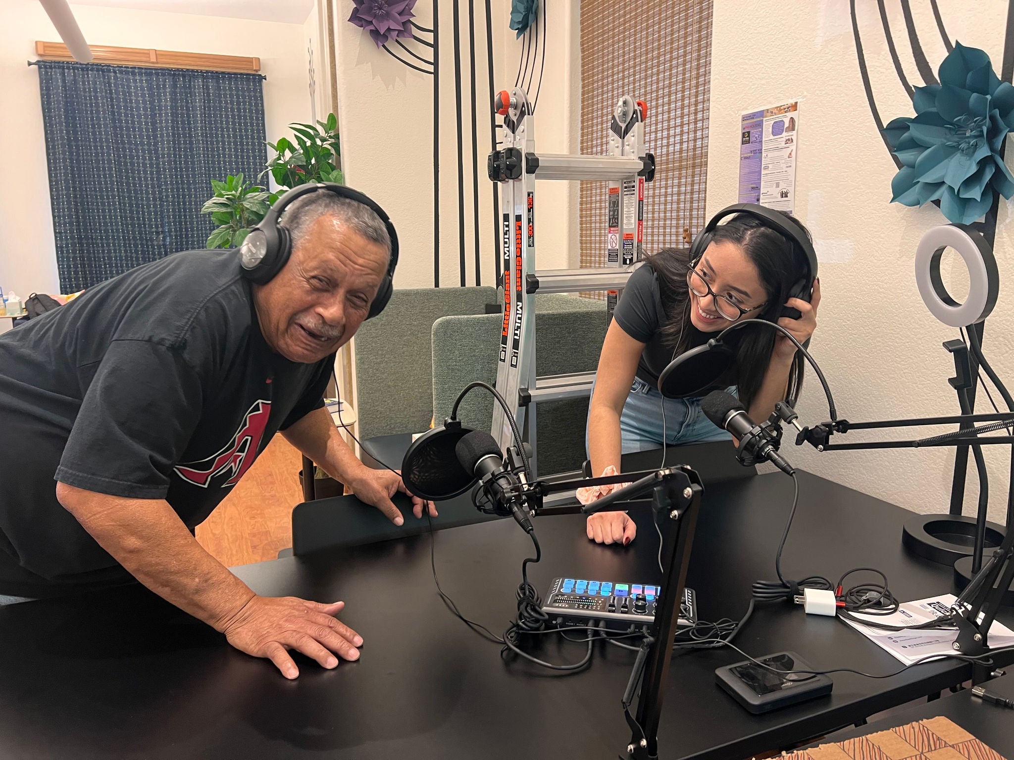 computer lab instructor and student using earphones smiling