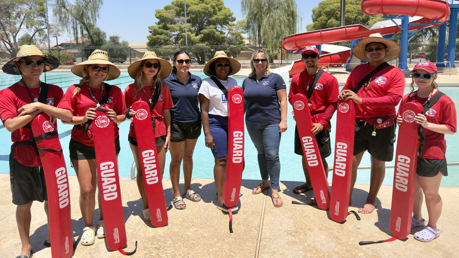 Councilwoman Kesha Hodge Washington stands alongside several City of Phoenix lifeguards in front of a city pool.