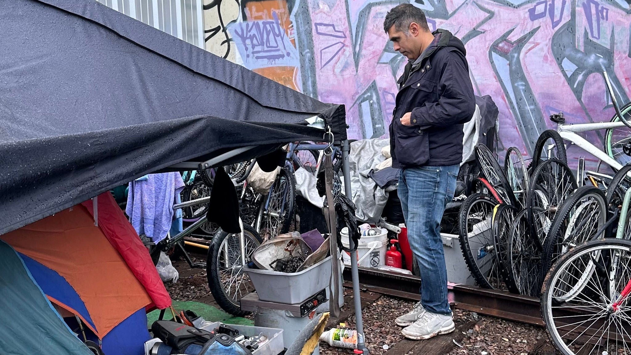 Office of Homeless Staff member surveys an encampment.
