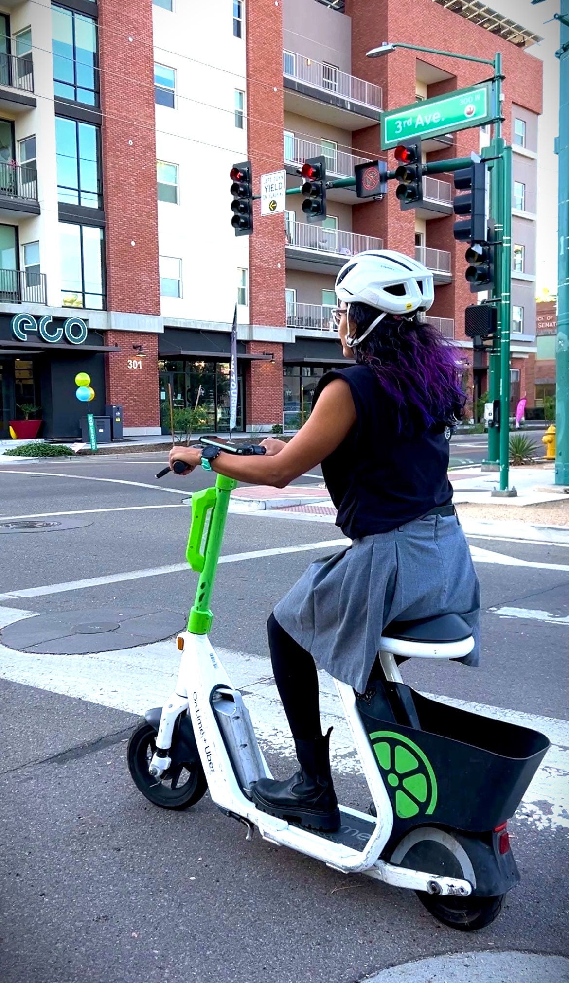 Woman on seated scooter at roadway intersection