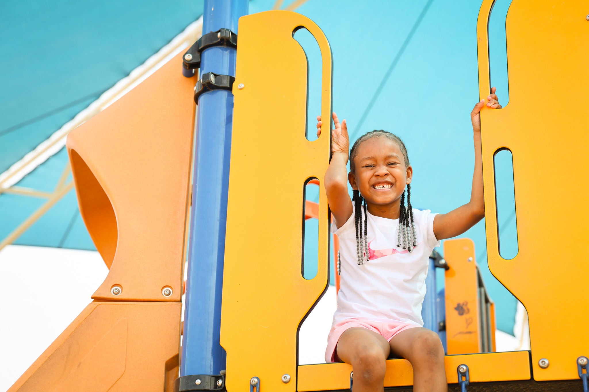 Children sitting on playground equipment. 