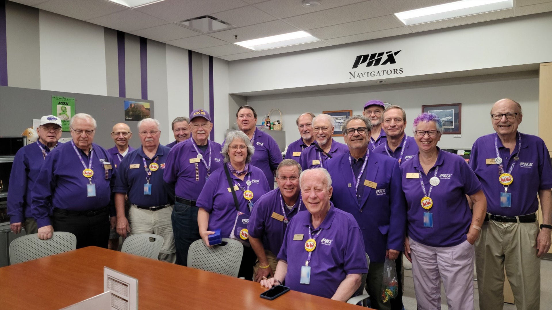 Navigator Volunteers dressed in purple pose for a group photo