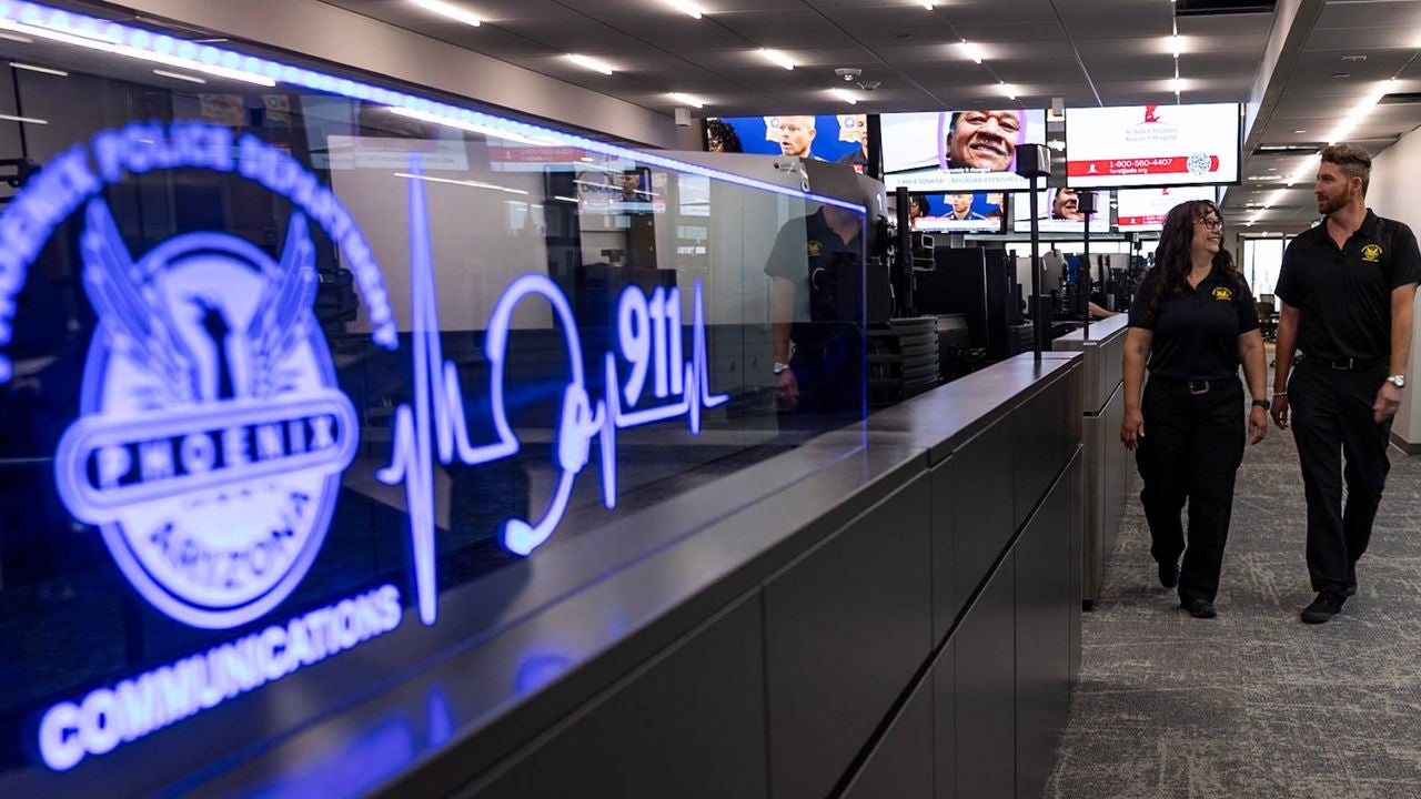 Two Phoenix PD Communications Bureau employees walking in the new Communications Center at future headquarters