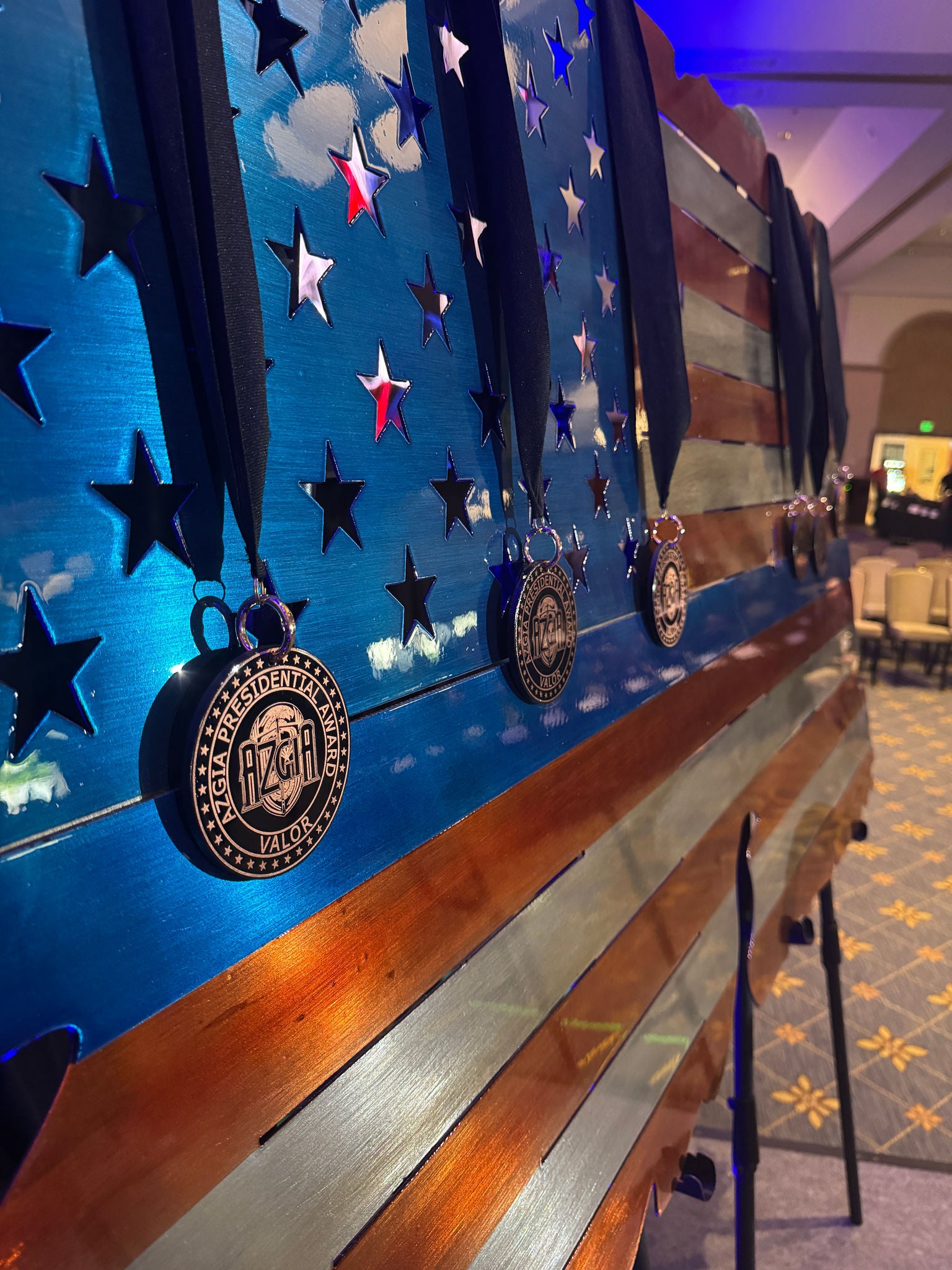 Medals of Valor hung over an American flag at the annual AZGIA conference