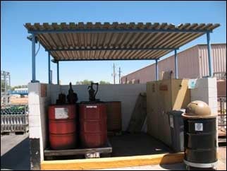 Chemicals stored with secondary containment and covered.