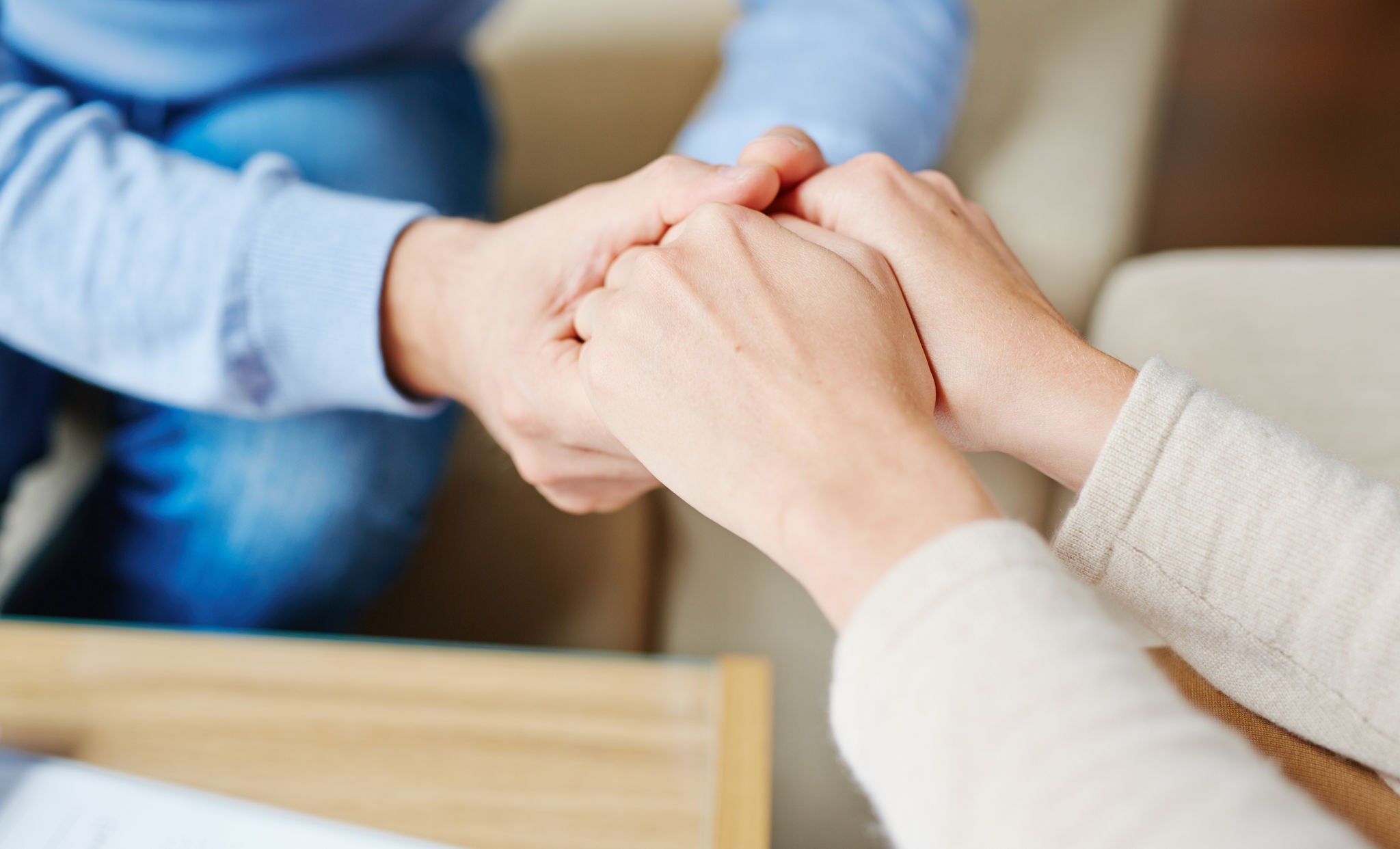 Close-up of psychiatrist hands in those of patient