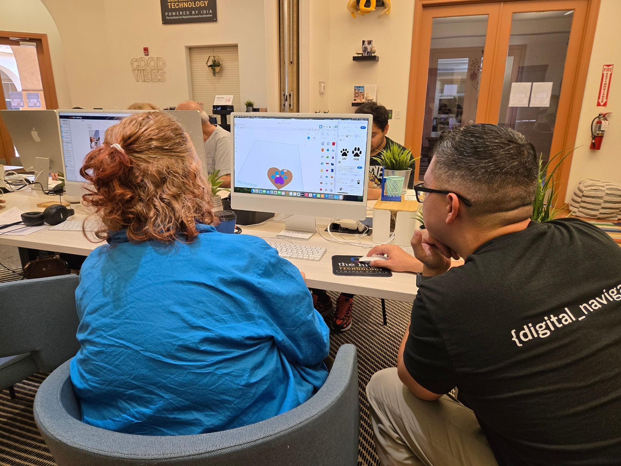 computer lab instructor and senior resident looking at a Mac computer