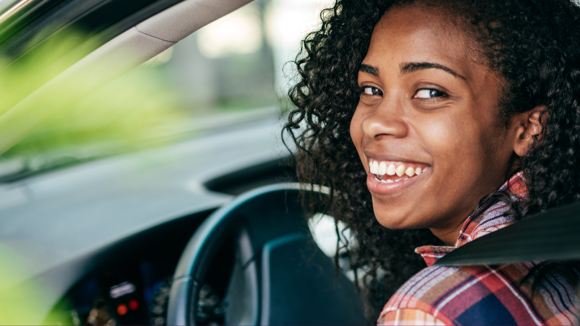 Woman in driver's seat of vehicle.