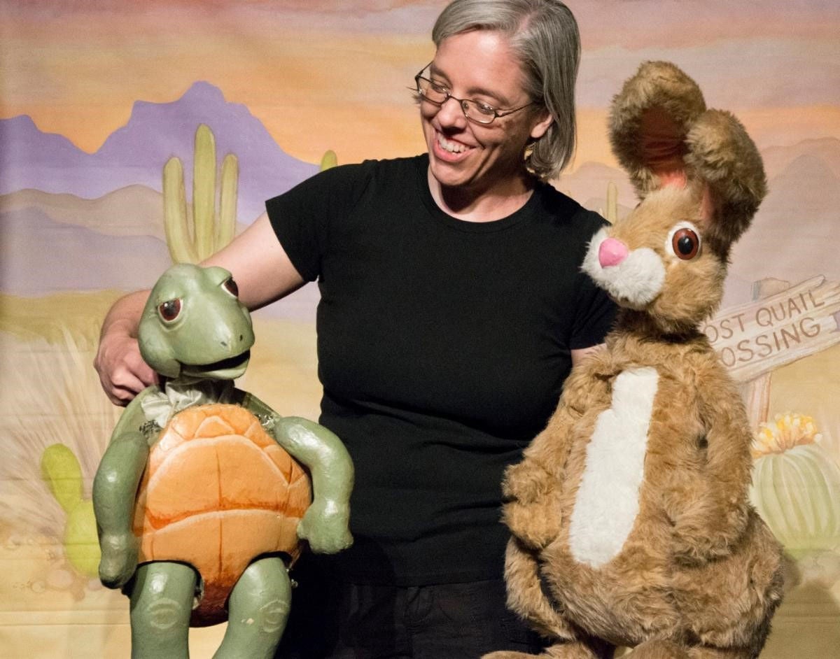 Man with turtle and hare puppets